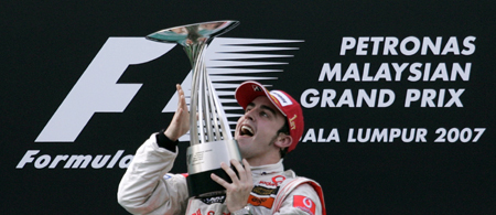 Alonso leads McLaren one-two in Malaysia - McLaren's Formula One driver Fernando Alonso of Spain celebrates as he holds his trophy after winning the MaLaysian F1 Grand Prix in Sepang April 8,2007.
