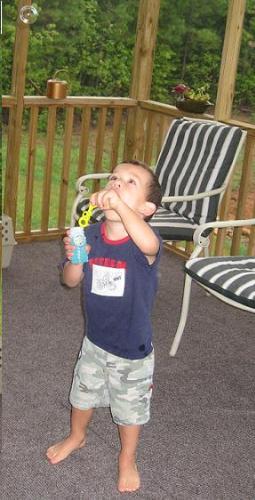 Blowing bubbles - Jayden is blowing bubbles on the porch.