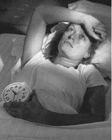 Insomnia - This photo is a woman obviously suffering from insomnia; she is lying in bed, it is clearly late at night, but she is still wide awake.