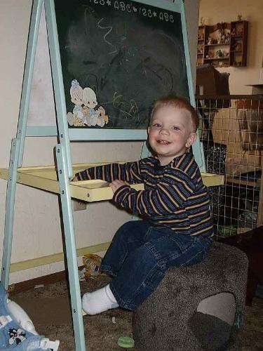 son sitting at the drawing board - My toddler sitting at the drawing board coloring on it. Very cute and playful.