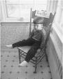 * - Picture of a child sitting in a chair, with a sign attached stating 'Time Out'