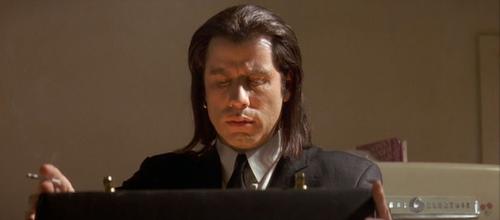 John Travolta as Vincent Vega in Pulp Fiction - Here we see Travolta&#039;s character, Vincent Vega, opening the mysterious briefcase that his employer, Marsellus Wallace, has him trying to track down from a group of petty thieves who stole it.