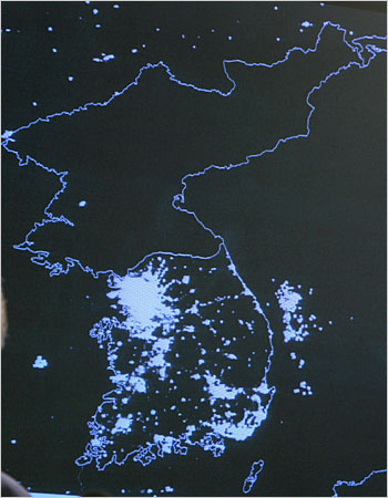 north korean - A Department of Defense satellite image of the Korean Peninsula showing wide illuminated areas in South Korea and the relative darkness of the North.