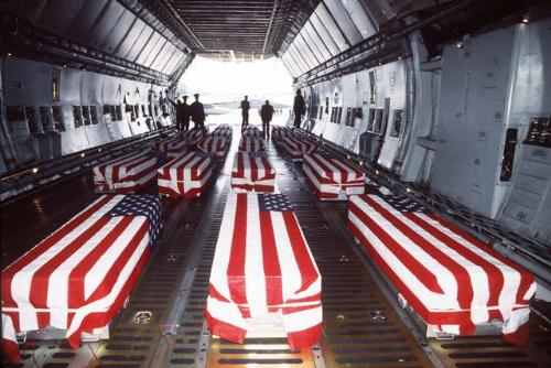 Flag Draped Caskets - Nineteen flag draped caskets containing the remains of U.S. military service members sit inside a C-5 Galaxy at Dover Air Force Base, Del., awaiting removal for a memorial service.
