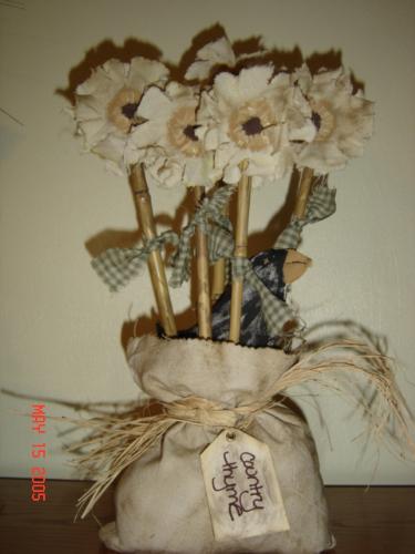 Primtive arrangement - I took material, cut it to shape, tea stained it, glued flowers to bamboo, then placed them in weighted sack, added grungy tag....Voila!