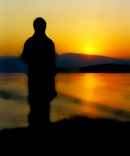 Lonely sunset - A nice shady photo of a silhouette watching the sunset. Expresses a loneliness feeling.