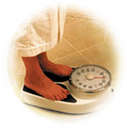 Weight loss! - this is a picture of a person standing on a scale but only their feet and the scale are showing.