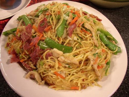 pancit - Sauteed noodles with fresh vegetables with bits and slices of meat.