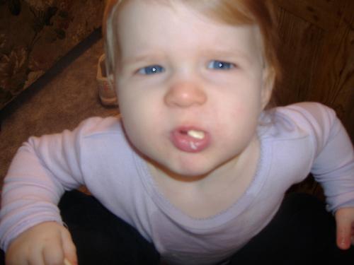 Hello? - Marissa eating a snack and trying to look into the camera lense to see what is in there.