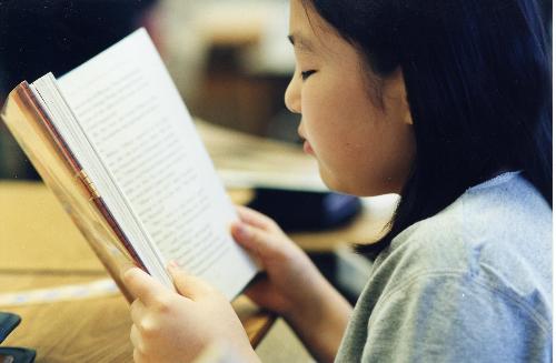 Girl Reading - reading to your children early might make them more interested as they get older.