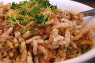 Bhel puri  - Puffed rice and sev, a fried snack made from besan flour, form the base of the bhel