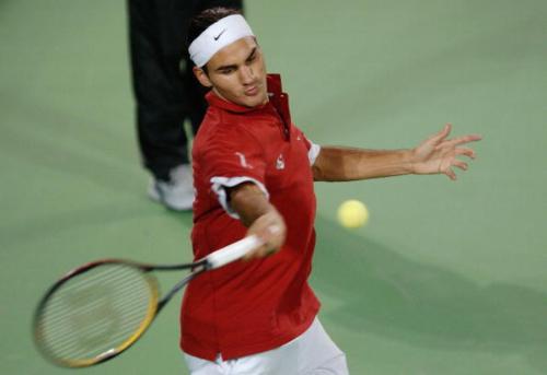 Federer - Roger Federer goes for a ferocious and powerful forehand .