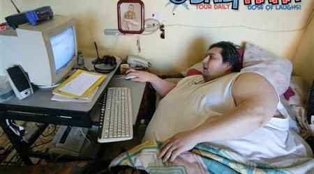 Computer addict - A man is completely hooked on the world wide web. Just look at his ballooning waist.