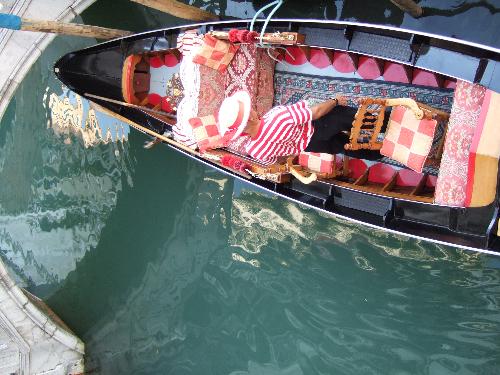 Gondola, Gondoleer - Taken from a bridge in Venice, Italy (May 2006). A colorful picture of a gondoleer steering some tourists through the blue-green water alleys of Venice. This picture is taken from a unique angle. You can only see the mood in this picture, you can't hear anything, but the gondoleer was singing (belting) an Italian song. He caught everyone's attention. Gondolas are sweet.