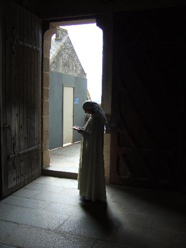French Nun - I took this picture in France during May 2006. My sister and I had just climbed to the top of this castle in a small town between Arromanches and Paris. At the top was a chapel, and inside I found this picture opportunity. The picture is of a nun standing just inside the exit of the chapel. The light from outside comes in just enough to make a silhouette around her, and her bowed head made for a great picture of reverence. She had on her robe of all white, which added to the images mood of holiness. I'm not sure how she didn't see me taking her picture, hahaa, my sister was a little embarrassed because I was being pretty obvious about it, ha.