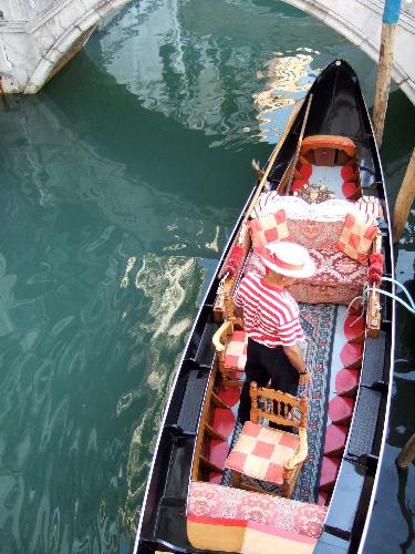 Gondola color - Taken from a bridge in Venice, Italy (May 2006). A colorful picture of a gondoleer steering some tourists through the blue-green water alleys of Venice. This picture is taken from a unique angle. You can only see the mood in this picture, you can't hear it, but the gondoleer was singing (belting) an Italian song. He caught everyone's attention, haha. Gondolas are sweet.