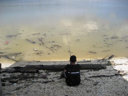 Lone fisherman. - A lone fisherman waits patiently for his catch.