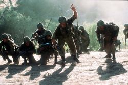 We Were Soldiers - We Were Soldiers is often regarded as one of the few films, along with John Wayne's The Green Berets (1968), to offer a positive representation of the American presence in Vietnam. However, the movie is somewhat ambivalent about the morality of the war, presenting the North Vietnamese army as a capable and brave opponent, and concluding with a statement that the U.S. soldiers did not fight for their country, but for each other. Some see the scenes toward the end of the movie as anti-war in their depiction of the horror of the fighting, as well as the graphic depiction of the loss of life, although other may see this as a realistic presentation of battle. The movie portrays Lieutenant Herrick's death, to the words 'I'm proud to die for my country,' as being caused by needless enthusiasm. The bereavement of the dead soldiers' families are also emphasized, particularly that of 2nd Lt. Jack Geoghegan's family, and also that of an un-named NVA soldier (actually a chinese advisor for the NVA, an incident that actually happened in the battle, but contrary to what is depicted in the movie, the body was not recovered in the aftermath of the battle -the NVA had probably taken great pains to recover it and carry it away before it could be recovered by US forces, as it was a matter of pride for them to officially have no foreign advisors in the field (while in reality they had both chinese advisors -in north and south, mostly for infantry training- and soviet advisors in the north -mostly for setting up SAM and AAA sites and train the vietnamese to man them)). The film also showed how political strife at home crept into the war. Moore detested this and even disregarded orders from his superiors when they were politically motivated.  Certain aspects of the film are heavily dramatized and edited. The final bayonet charge by the American troops on the North Vietnamese base camp is completely fictitious and quite out of character with the rest of the film. Historically, the battle ended with the withdrawal of North Vietnamese forces and subsequent extraction of 1/7 by helicopter after they were relieved by 2nd/7thCav which had marched overland from LZ Falcon to LZ X-Ray. The presence of this other 7th Cavalry battalion, 2nd Battalion (2/7) (as well as that of a platoon from the 2nd/5thCav which happened to be there 'on loan' to the 2nd/7th), is ignored during the movie, as well as the battle of LZ Albany which took place barely 2 miles from X-Ray, while the 2nd/7th left LZ X-Ray (B-52 strikes were planned on the Chu Pong slopes, and X-Ray was considered 'danger-close' to these strikes, so the LZ had to be cleared first) and marched overland to LZ Albany in what was to be the least airmobile operation in the war (raising much controversy, for the documents pertaining to the chain of command who issued this order were apparently lost or destroyed on purpose), only to stumble on the 66th NVA regiment which happened to be bivouacking in their path, resulting in a much bloodier battle than that of X-Ray (try imagining X-Ray with the US caught completely by surprise, in grass 2m tall, mostly without radios (HQ squad was destroyed first in the ambush), and with little air and artillery support -which claimed almost as much friendly as NVA lives). This, combined with the fictitious bayonet charge, lends the film an air of revisionism, or amateurism at the very least. Expert eyes may also recognize national guard uniforms in figurative roles instead of genuine Cavalry uniforms.  The movie also hints that the first meeting between Moore and Galloway happened during the battle of LZ X-Ray, while in fact Galloway had been following the 7th Cav on operations (always staying with them where they were, even in mud and rain, while most other field reporters chose to hook a ride on a resupply chopper back to the base for a hot supper and shower) for the better part of a month before the battle actually took place.  Aviation experts may also notice a big goof in the end of the movie (right at the time of the bayonet charge) : before Moore leads the bayonet charge, a Huey Gunship is seen mowing down the NVA base camp with twin-mounted M134 gatling guns ('miniguns'). This is an anachronism : while in late 1965 Hueys were already equipped with the 2.75' rockets shown in the movie, the XM134 minigun hadn't been issued to ARA (Aerial Rocket Artillery, name used by the GIs to differentiate them from the howitzer cannon-cockers, which they simply called 'tube artillery') helicopters yet. At this time they were still equipped with a twin M-60 'flex-gun' on each side (those were M-60s that could rotate in a 70° cone and aimed by the copilot via a suspended joystick in the cockpit). XM134 (7,62mm) guns were not fitted to Hueys until 1966 (they would later use 12.7mm gatlings, as well as 20mm gatlings on later Huey Cobra gunships in order to engage .50cal machine gun nests from a safe distance). Strangely, the Huey gunship appears to be flown by Crandall, who actually was assigned an AHC (assault helicopter company), while Huey gunships were commanded by ARA folks (in the case of X-Ray, they were under the command of the famous 'Black Bart', later killed in action in 1968), so Crandall couldn't have been flying that gunship. The movie also depicts the crash of one 'slick' (troop transport chopper) and his pilot/copilot killed, while in fact two helicopters were damaged during the battle and forced to stay grounded, but none actually crashed. The crewmen were evacuated on a troop transport Huey, and as the 1st/7th was being evacuated from X-Ray the crippled Hueys were airlifted back to Pleiku for repair. What the movie doesn't depict however, and which actually happened, is the loss of a US Navy A1 Skyraider 'Spad' which was downed -presumably by fragments of his own ordnance- killing its pilot (bombs and napalm have very different safe separation altitudes, the pilot probably meant to drop a napalm canister, flicked the wrong switch in the cockpit, dropped a 250-lb bomb instead and his aircraft, flying too close to the ground, was damaged by shrapnel).