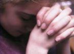 praying - a woman praying. In her middle age, she solemnly pray to God.