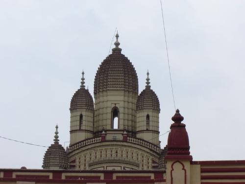 Dakshineswar Kali Temple - The Dakshineswar Kali Temple is a Hindu temple located in Dakshineswar locality, Kolkata. Situated on the eastern bank of the Hooghly River, the presiding deity of the temple is Bhavatarini, an aspect of Kali. Photography within the temple compound is prohibited. The temple compound, apart from the nine-spired main temple, contains a large courtyard surrounding the temple, with rooms along the boundary walls. There is a bathing ghat on the Hoogly river, a bookshop, a shrine to Rani Rashmoni, a parking lot and twelve shrines dedicated to the aspects of Shiva, Kali's companion, and to Radha-Krishna. The chamber in the northwestern corner just beyond the last of the Shiva temples, is where Swami Ramakrishna Paramahamsa spent a considerable part of his life.