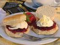 Scones - A cream tea, with scones filled with strawberry jam and cream.