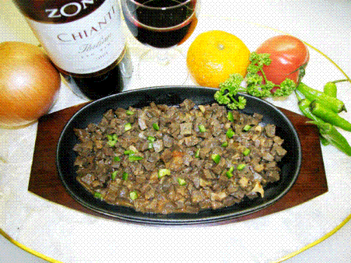 Sisig - A Philippine Delicacy  1 kg Pork Face 1/4 kg Pork Brain (Optional) 2 tsp. butter 4 pcs. Onions, chopped 3 Tbsp. Soy Sauce 1 Tbsp. Vinegar 1 Tbsp. Catsup or Chili Sauce salt and pepper to taste Fried Pork skin, grounded(Optional) 1 egg(Optional)   1. Boil Pork face till tender; slice thinly into cubes. 2. Saute 1 pc. onion in butter and add the sliced pork face and the brain in a deep skillet. 3. While sauteing, mix the liquid ingredients. 4. Add the liquid mix in the pan. Simmer for about 15 mins. 5. Serve in sizzling plate, garnish with Fried Pork skin and egg.