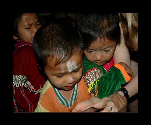 Hill tribe children looking at digital camera - This is a picture of children in a hill tribe of northern Thailand. They were absolutely fascinated by our digital cameras, we would take a picture of them - then show it to them and they&#039;d be like "WOW! THATS ME!!" so to speak... It was so much fun, they are so adorable. 