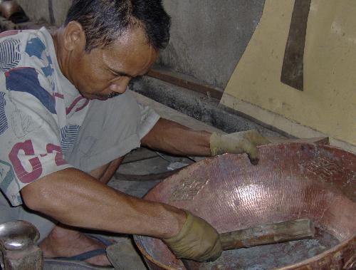 hardwork - this pic was taken at a warehouse in Indonesia at the copper village. The person was busy with his craft whilst i took pics. A lot of men were present, each concentrating to finish their task without any hassle. Any disturbance or distractions could mean to do the work all over again for them. They shape and polish all items without the aid of machines, making the product they make higher in value and craftsmanship.