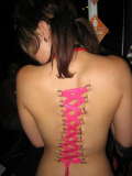 Pain - Woman with spine laced tightly to signify pain.
