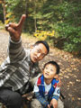Father - Father and son in forest, father pointing, arm around son.