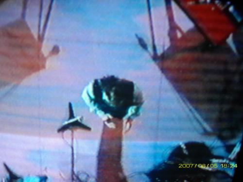 Which Singer entertaining crowd with which song ? - Simplistic music performed by amazing entertainer entertaining small or large crowds in secluded lounges or noisy stadiums. This is an 'aerial' view of the top of his head . . . whose might it be?