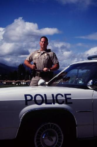 Police Officer and Patrol Car - This is a photo of a police officer and his patrol car....when a person breaks the law they should beware of this site outside their house...LOL