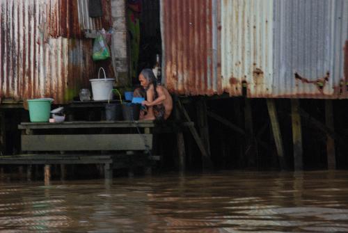 granny have a bath by the river - this is a pic that i took in my trip to banjarmasin,indonesia.many houses build above the river.this is a pic of an old woman want to take her bath by the river