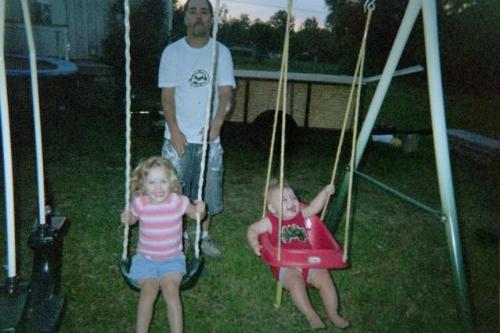family - this is my niece and nephew swinging with my brother in law behind then