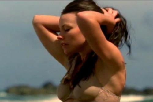 Evangeline Lily in beach scene season 1 of Lost - Evangeline, Kate, starting to tie her hair up as she standing in shallow water and rinsing off in her underwear in Lost season 1.
