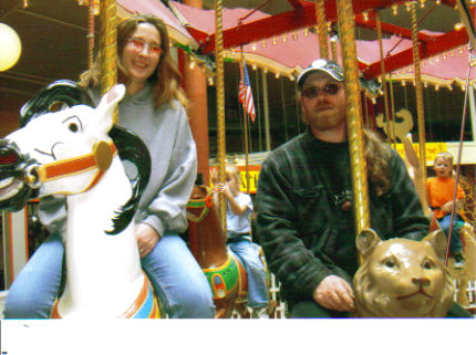Riding the carousel in Seaside Oregon - This is my hubby and I riding the carousel