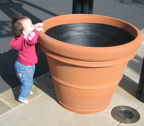 Do you hide your key under the flowerpot? - A picture of a cute child looking at a big flowerpot. Taken with permission from http://farm1.static.flickr.com/29/62591347_c747de606a.jpg?v=0 .