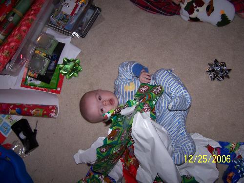 zach trying to wrap himself - zach playing in his wrapping paper on his first christmas. i think he was trying to regift himself
