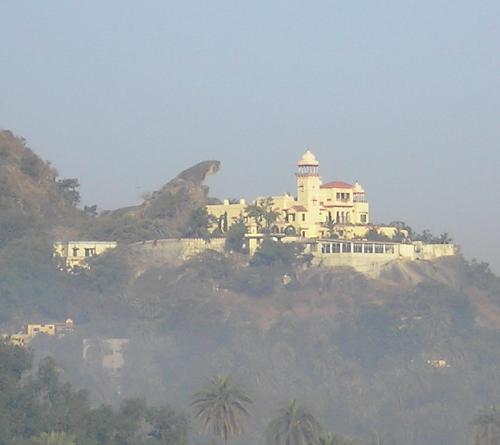 Nature Created and Man-made structures - Juxtaposing man-made palace and the mature created toad-rock, through the fog, in the morning time! This looks like a palace with its protector!