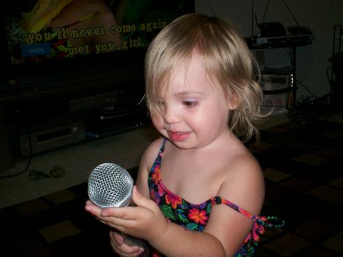 Maddy - This is Maddy, holding a microphone. Her grandpa loves to sing& even has his own karaoke setup at home. We were visiting them in Maryland,& he was singing for us. Maddy& the boys grabbed the extra microphones& joined in.
