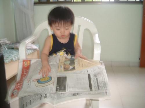 Reading newspapers - My two year old son trying to read the newspapers.