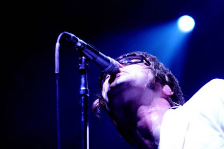 Oasis Pictures - After playing a handful of small club gigs, the band cornered Alan McGee, the head of Creation Records, and forced him to listen to their demo. Impressed, he signed the band. The group released their first single, 'Supersonic,' in the spring of 1994; it edged its way into the charts on the back of positive reviews. With a melody adapted from 'I'd Like to Teach the World to Sing,' 'Shakermaker' became a bigger hit in the early summer. Released a month before their debut album, the soaring ballad 'Live Forever' became a major hit in England. The group's first record, Definitely Maybe, became the fastest-selling debut in British history, entering the charts at number one. Oasis mania continued throughout 1994, as the group began playing larger theaters and each new single outperformed the last. However, tensions in the group began to build -- Liam and Noel refused to do joint interviews because they always fought -- and Noel Gallagher briefly left the band at the end of a difficult fall American tour; he soon re-joined and the band headed back to England. As 'Supersonic' began to climb the U.S. album rock and modern rock charts, the non-LP, string-laden 'Whatever' hit number two over the British Christmas season.  At the beginning of 1995, the group concentrated on America, promoting the single 'Live Forever.' The song became a major hit on MTV, album rock, and modern rock radio stations, peaking at number two, and Definitely Maybe went gold in the U.S. Returning to England after a sold-out American tour, the group recorded a new single, 'Some Might Say.' On the eve of its release, drummer Tony McCaroll parted ways with the band, with Alan White taking his place. 'Some Might Say' entered the charts at number one upon its May release; its success led to all of their previous singles re-entering the indie charts. Oasis spent the rest of the summer completing their second album, (What's the Story) Morning Glory?, which was released in October of 1995. Upon its release, the album shot to number one in England, becoming the fastest-selling in the U.K. since Michael Jackson's Bad.