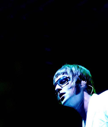 Oasis Pictures - After playing a handful of small club gigs, the band cornered Alan McGee, the head of Creation Records, and forced him to listen to their demo. Impressed, he signed the band. The group released their first single, 'Supersonic,' in the spring of 1994; it edged its way into the charts on the back of positive reviews. With a melody adapted from 'I'd Like to Teach the World to Sing,' 'Shakermaker' became a bigger hit in the early summer. Released a month before their debut album, the soaring ballad 'Live Forever' became a major hit in England. The group's first record, Definitely Maybe, became the fastest-selling debut in British history, entering the charts at number one. Oasis mania continued throughout 1994, as the group began playing larger theaters and each new single outperformed the last. However, tensions in the group began to build -- Liam and Noel refused to do joint interviews because they always fought -- and Noel Gallagher briefly left the band at the end of a difficult fall American tour; he soon re-joined and the band headed back to England. As 'Supersonic' began to climb the U.S. album rock and modern rock charts, the non-LP, string-laden 'Whatever' hit number two over the British Christmas season.  At the beginning of 1995, the group concentrated on America, promoting the single 'Live Forever.' The song became a major hit on MTV, album rock, and modern rock radio stations, peaking at number two, and Definitely Maybe went gold in the U.S. Returning to England after a sold-out American tour, the group recorded a new single, 'Some Might Say.' On the eve of its release, drummer Tony McCaroll parted ways with the band, with Alan White taking his place. 'Some Might Say' entered the charts at number one upon its May release; its success led to all of their previous singles re-entering the indie charts. Oasis spent the rest of the summer completing their second album, (What's the Story) Morning Glory?, which was released in October of 1995. Upon its release, the album shot to number one in England, becoming the fastest-selling in the U.K. since Michael Jackson's Bad.
