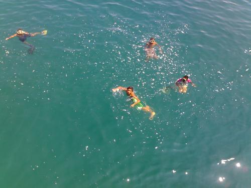 kids at the ocean - these are kids swimming at the ocean in order to get the coins thrown by the passengers in the passing ships