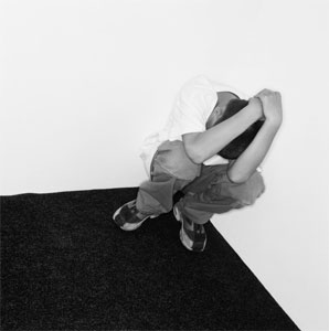 A small child bending in the corner probably out o - A small child bending in the corner probably out of fear of his abuser.