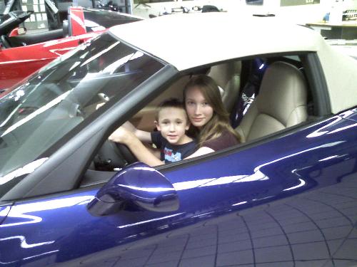 kids in car - This is my eldest daughter and youngest son in a very expensive car in the dealership on display. We got bored. ha ha