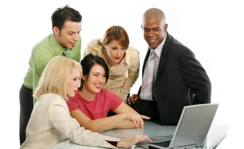 Work - Several people surrounding a laptop computer, figuring out what to do next and meanwhile they are trying to train each other to use the program. They use each other's guidance to get through it.