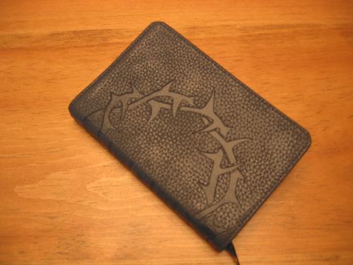 Bible - Thorn crown etched leather Bible on wood table taken by Raielene Langdon.