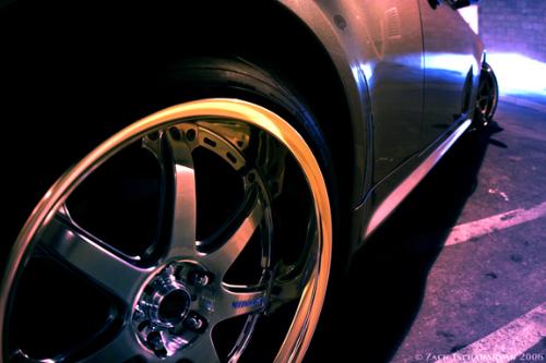 2005 Nissan Skyline GT-R - Silver 2005 Nissan Skyline GT-R with blue HIDs of zoomed rim from low passenger angle parked in lot at night