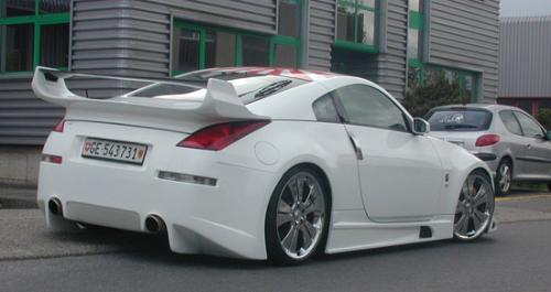 2004 Nissan 350Z - White 2004 Nissan 350Z with extreme body kit, gunmetal rims, and extreme spoiler from rear passenger side angle parked on street